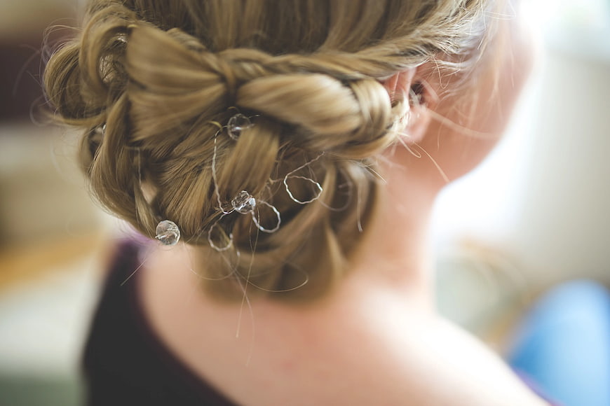 Close-up of blonde braided updo with crystal hair accessories