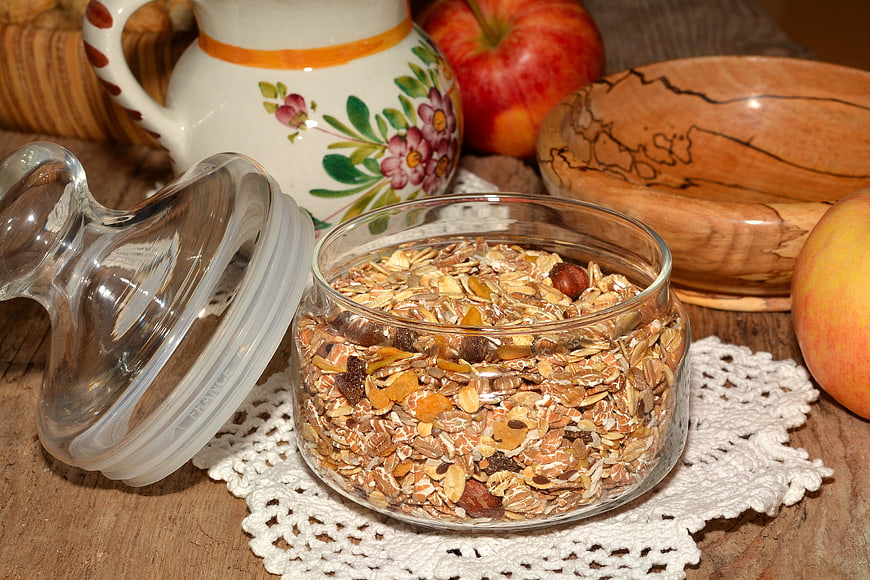 Homemade Granola in Glass Jar with Apples and Wooden Bowl