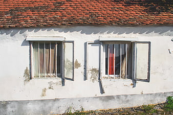Old White House with Weathered Windows and Red Roof