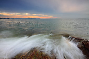 Long Exposure Sunset Waves Crashing on Rocky Coastline