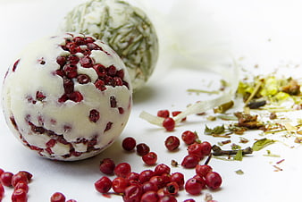 Handmade herbal bath bombs with red peppercorns and dried herbs