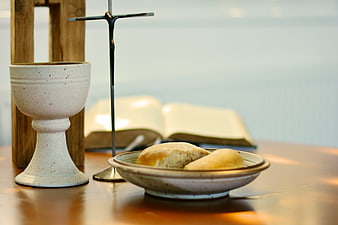 Christian communion elements with bread, chalice, cross, and bible