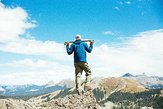 Hiker standing on mountain peak looking at view