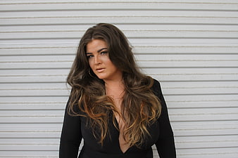 Confident Brunette Woman Portrait Against White Wall