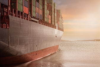 Massive Cargo Ship Sailing at Sunset