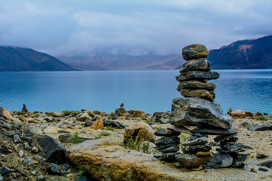 Stacked Rock Cairn by Lake with Mountains