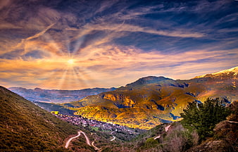 Sunset over Greek Mountain Village with Golden Sun Rays