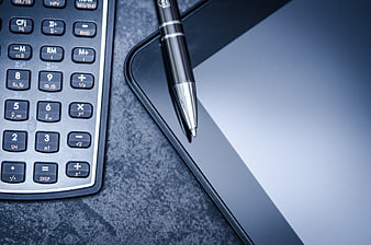 Scientific Calculator, Pen, And Tablet On Dark Desk
