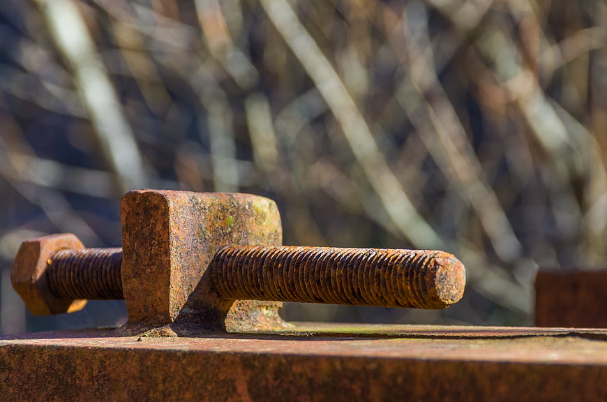 Close-up of rusty metal bolt and nut on steel beam