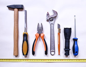 Assorted Hand Tools and Flashlight Arranged on White Background
