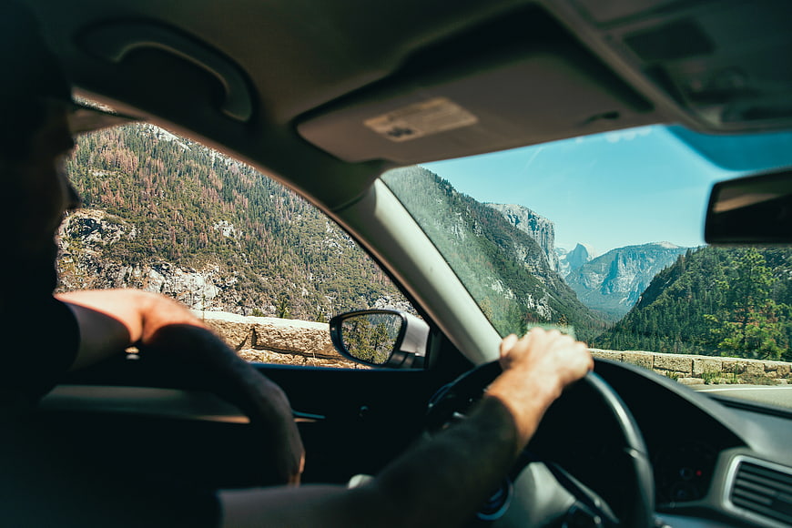 Man driving car through scenic mountain landscape