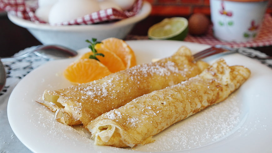 Rolled Crepes with Powdered Sugar and Orange Slices