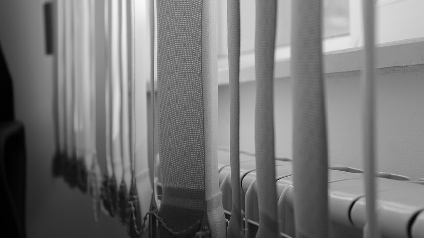 Black and white close-up of hanging crochet curtains