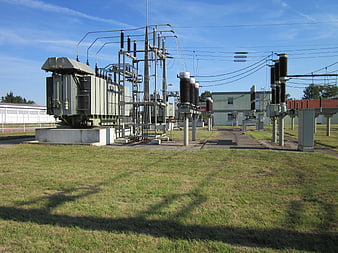 Electrical Substation With Transformer And Insulators On Grass
