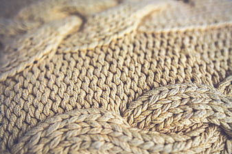 Close-up of beige knitted wool texture with soft focus