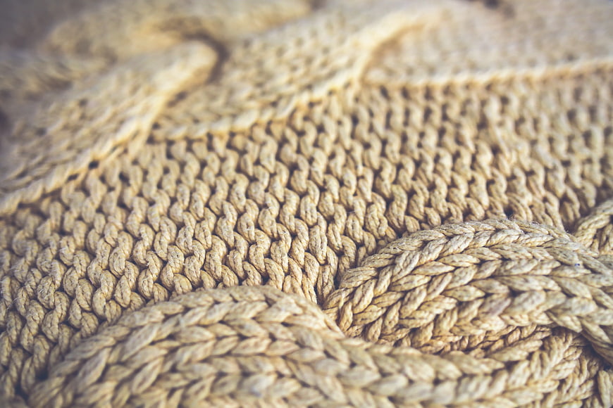 Close-up of beige knitted wool texture with soft focus