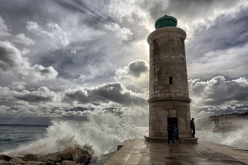 Dramatic Lighthouse with Crashing Waves and Stormy Sky