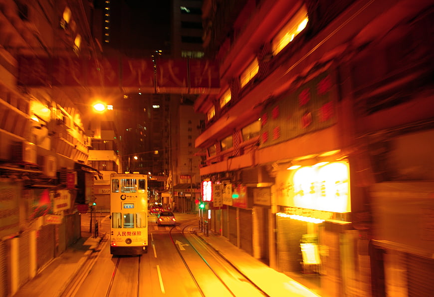 Motion blur of a tram on a neon-lit Hong Kong street at night