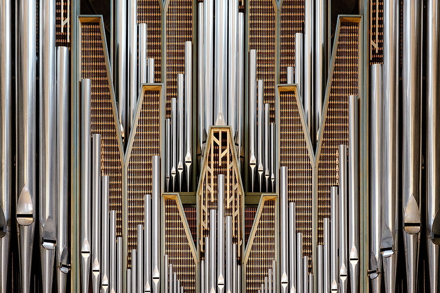 Symmetrical Close-Up of Silver and Gold Church Organ Pipes