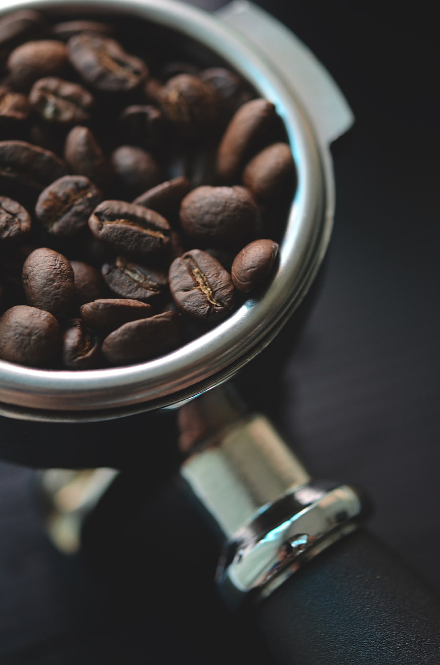 Close-up of roasted coffee beans in portafilter