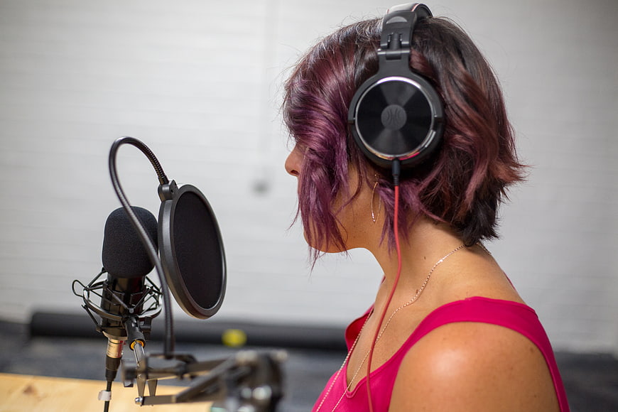 Woman with purple hair recording in studio