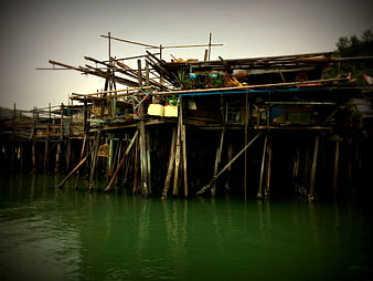 Rustic wooden stilt houses on a green river