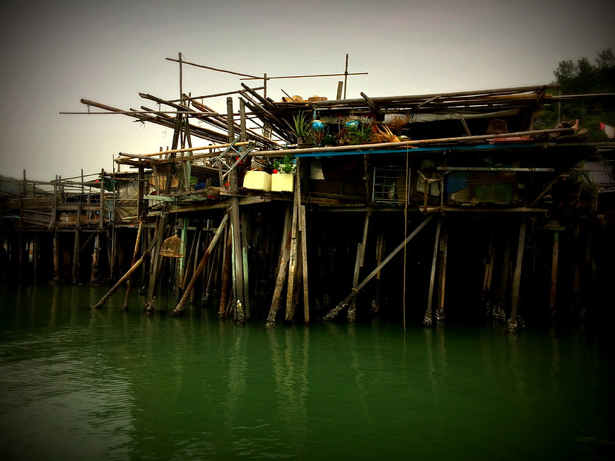 Rustic wooden stilt houses on a green river