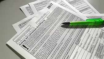 German tax forms and green pen on desk