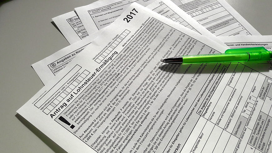German tax forms and green pen on desk