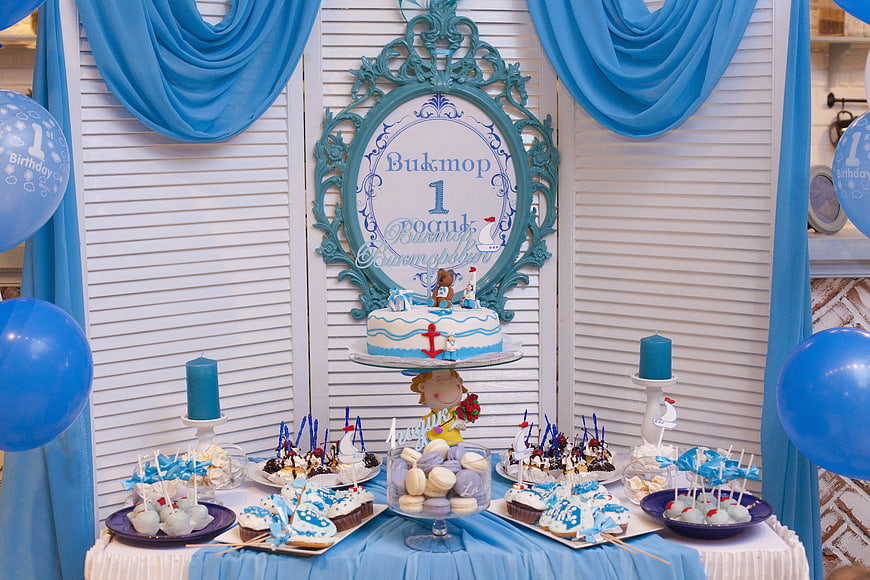 Nautical themed first birthday candy bar with blue cake and desserts