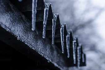 Icicles Hanging from Corrugated Metal Roof Edge in Winter