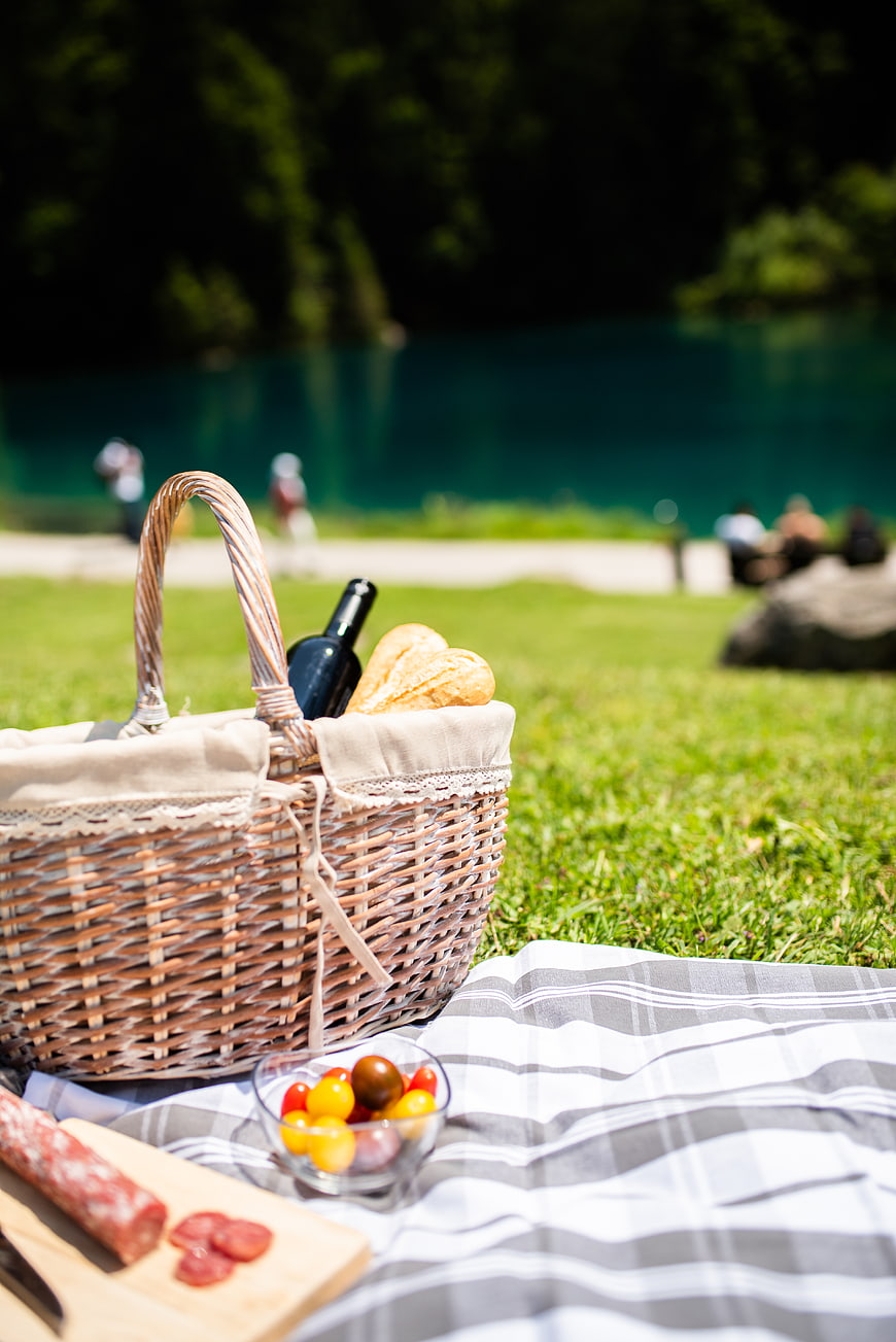 Summer Picnic Basket with Wine and Food on Grass