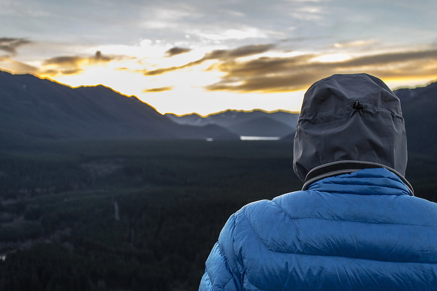 Hiker in Blue Jacket Watching Mountain Sunset