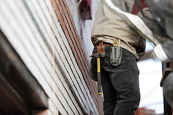 Construction worker with hammer and tool holster on belt