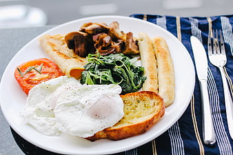 Healthy breakfast plate with poached eggs, sausage, and vegetables