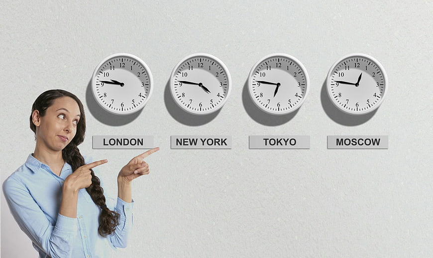 Businesswoman Pointing At World Clocks For Time Zones