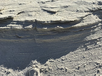 Close-up of textured sandstone rock layers in sunlight
