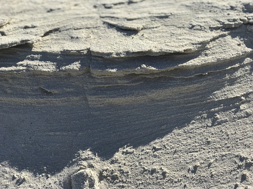 Close-up of textured sandstone rock layers in sunlight