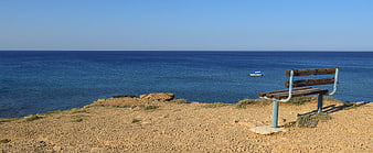 Lone Bench Overlooking Deep Blue Sea Horizon
