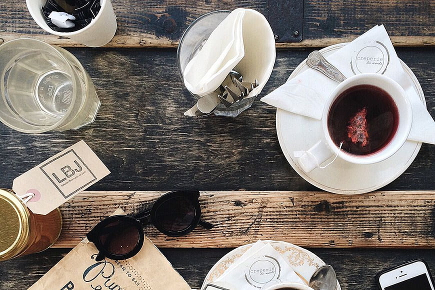 Flat Lay of Tea, Sunglasses, and Accessories on Rustic Wood