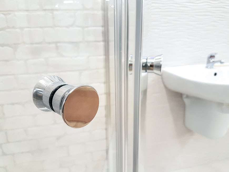 Close-up of modern chrome and copper bathroom door handle