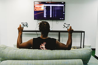 Man Playing Video Games on TV with Dual Controllers