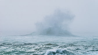 Majestic ocean wave crashing in misty stormy weather