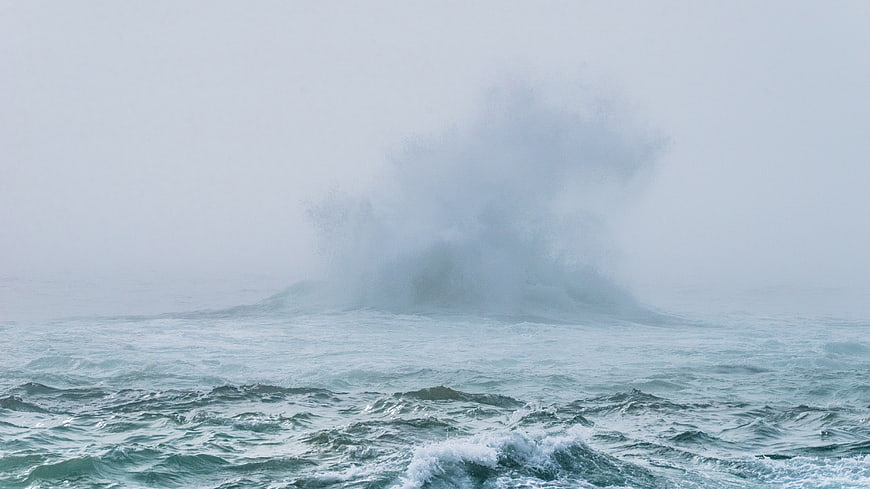 Majestic ocean wave crashing in misty stormy weather