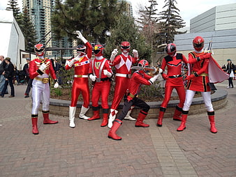 Group of Cosplayers in Red Power Ranger Costumes Posing Outdoors