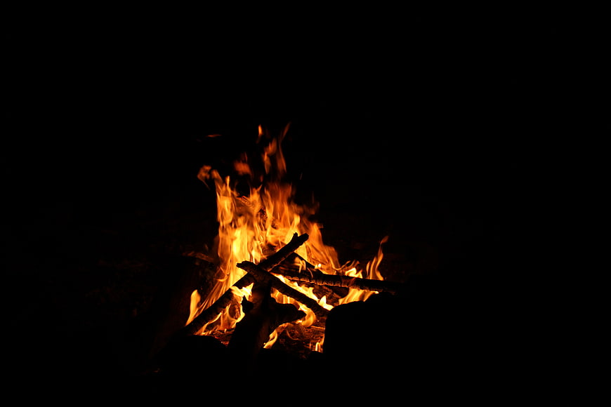 Campfire burning at night with bright orange flames