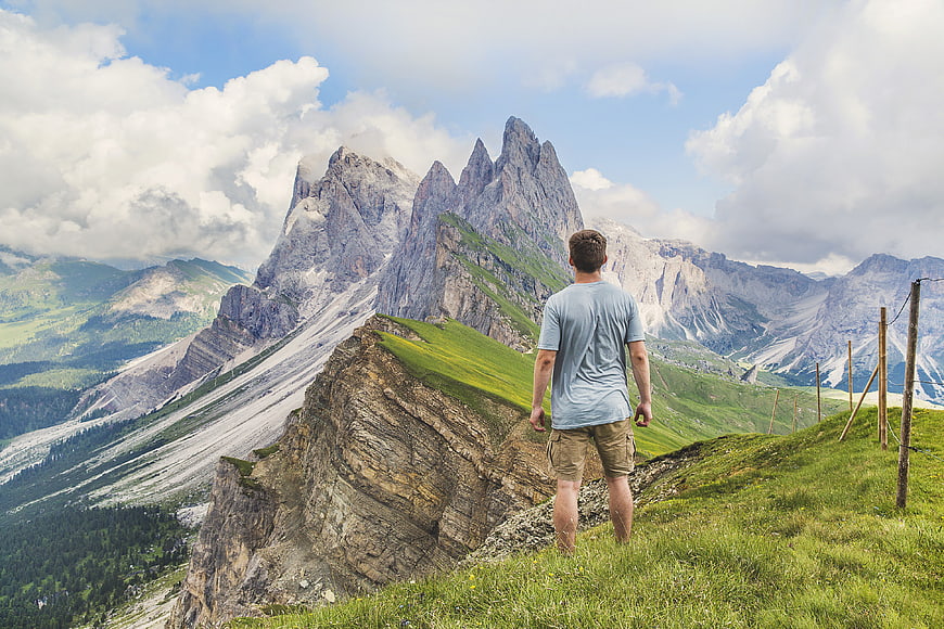Man Standing on Mountain Ridge Looking at Dolomites Peaks