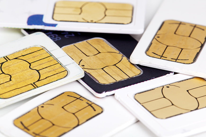 Close-up of scattered SIM cards on white background