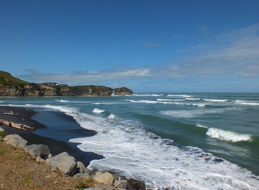 Scenic Black Sand Beach with Ocean Waves and Cliffs