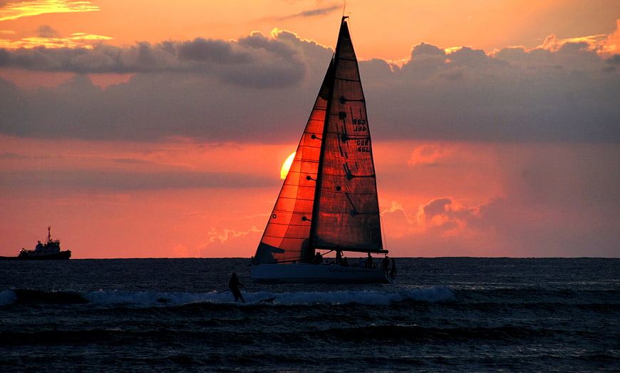 Sailboat Silhouette Against Vibrant Orange Sunset Sky